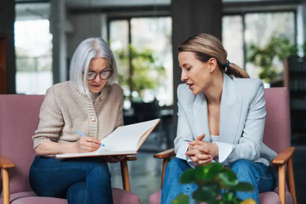 Two women consulting, one taking notes