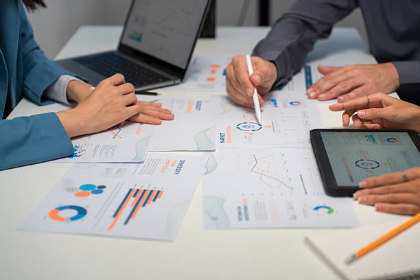The advisor uses a digital tablet in a close-up meeting to review mortgage loan options, tax implications and continuity planning with the couple.
